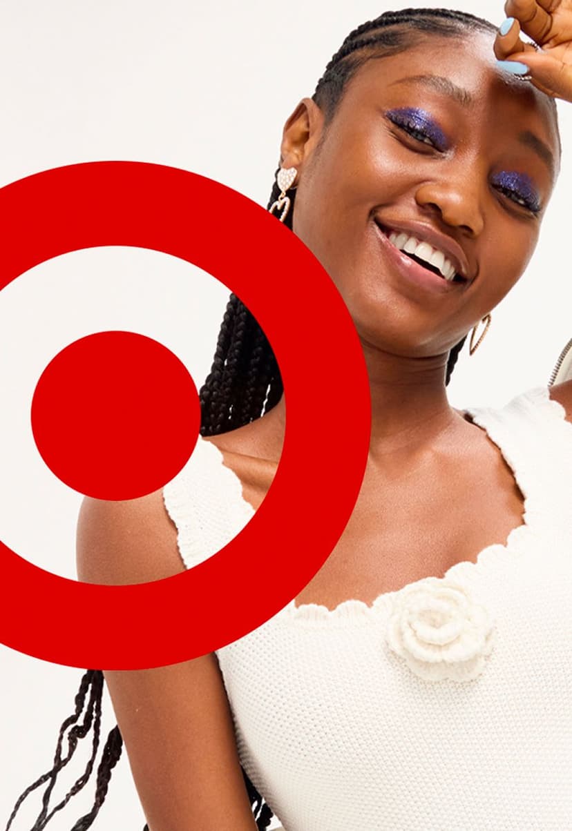 Smiling woman with braided hair and bold blue eyeshadow wearing a white sleeveless top with a knitted flower detail. A large red Target logo is partially overlaid on the left side of the image.